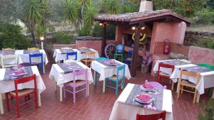 un grupo de mesas y sillas en un patio en Agriturismo Agrisole, en Olbia