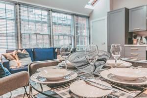 uma mesa de jantar com copos e pratos em 63 Chester Rows City Centre Apartment B by Rework Accommodation em Chester