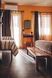 a bedroom with two beds and a desk and window at Resort Bacca Blu in Bricherasio