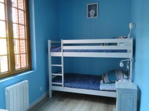a bedroom with two bunk beds in a blue wall at LA FERMETTE DE L'YERES in Aubermesnil
