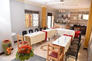a dining room with tables and chairs and a fireplace at Trinity Resort Hotel & Spa in Kampala