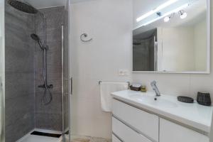 a white bathroom with a shower and a sink at Estudio 7 in Salobreña
