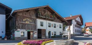 a building in the middle of a street with flowers at Biobauernhof Mesneranderl in Innsbruck