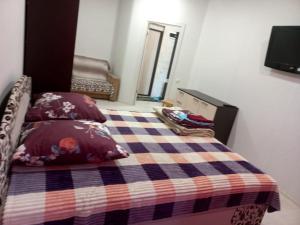 ラメンスコエにあるКвартиры в Раменскомのベッドルーム1室(チェック入りの毛布付きのベッド1台付)