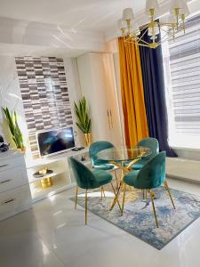 ein Esszimmer mit einem Glastisch und grünen Stühlen in der Unterkunft DeLight Apartments in Boryspil