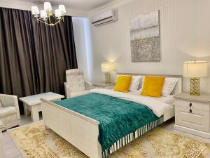 a bedroom with a bed with yellow pillows and a chair at DeLight Apartments in Boryspil