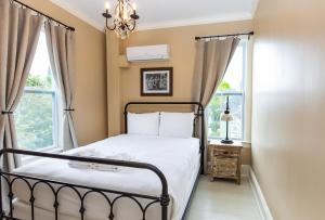 a bedroom with a bed and two windows at Pine Cottage Bed & Breakfast in Mackinac Island