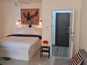 um quarto com uma cama branca e uma porta preta em לב הים- סוויטה זוגית עם ג'קוזי איטלקי em Netanya