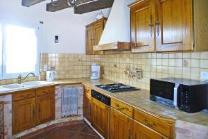 La cuisine est équipée de placards en bois et d'un four avec plaques de cuisson. dans l'établissement Cottage, Hillion, à Hillion