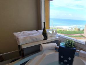 baño con lavabo y ventana con botella de vino en לב הים- סוויטה זוגית עם ג'קוזי איטלקי en Netanya