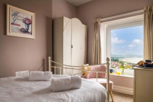 a bedroom with a bed and a large window at Windy Ridge Terrace with beautiful sea views, North Wales Coast in Old Colwyn