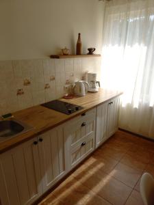 a kitchen with white cabinets and a sink and a window at Old Willows in Ventspils