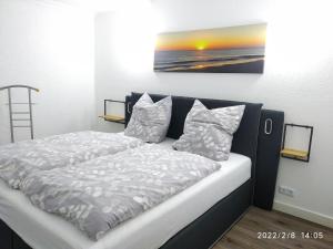 a bedroom with a bed and a painting on the wall at Ferienwohnung Christine in Jever