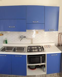 a kitchen with blue cabinets and a stove top oven at Al Ponte in Ferrara