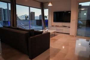 sala de estar con sofá y TV de pantalla plana en Villa Nirvana - Luxury Villa with Heated Pool, en Playa Paraiso