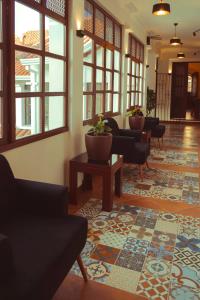 eine Lobby mit Stühlen, einem Tisch und Fenstern in der Unterkunft San Juan Suites in Sucre