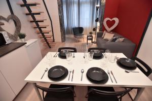 a white table with black plates and wine glasses on it at The APEX Residences in Budapest
