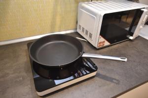 a frying pan sitting on top of a toaster oven at The APEX Residences in Budapest