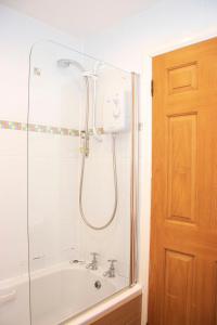 a bathroom with a shower with a tub and a sink at Craignelder Hotel in Stranraer