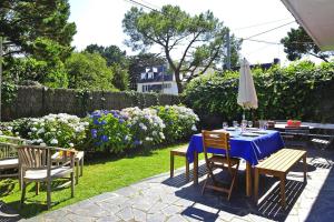 une table et des chaises dans un jardin avec un chiffon bleu dans l'établissement Cottage, Carnac, à Carnac