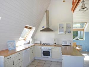 uma cozinha com armários brancos e um forno com placa de fogão em Holiday home with sea view, Pordic em Pordic