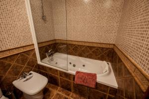 Un baño con bañera, inodoro y lavabo. en Casa Espinalbet, en Castellar del Riu