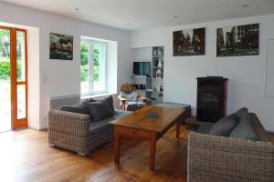 a living room with two couches and a table at Holiday Home in Moëlan near Kerfany Beach in Moëlan-sur-Mer