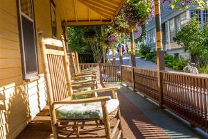 a wooden bench sitting in front of a patio at Pine Cottage Bed & Breakfast in Mackinac Island