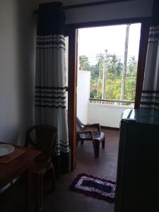a room with a window and a chair and a table at Villa Maleena in Hikkaduwa +35 photos