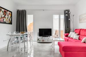 salon z czerwoną kanapą i stołem w obiekcie Lujoso piso en Casco Histórico,Playa del Postiguet w Alicante