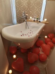 La salle de bains est pourvue d'une baignoire avec des coeurs rouges. dans l'établissement Penthouse Luxury, à Reşiţa
