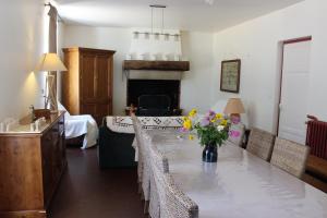 uma sala de jantar com uma mesa com cadeiras e uma lareira em Lou Prat em Meyrueis