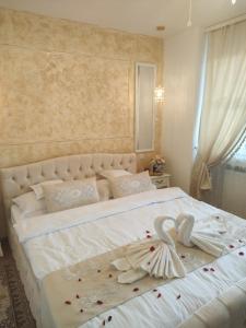 Un dormitorio con una gran cama blanca con flores. en Penthouse Luxury en Reşiţa