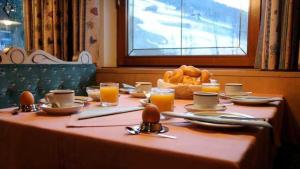 stół z talerzem chleba i szklanki soku pomarańczowego w obiekcie Pension Rieder w Alpbach