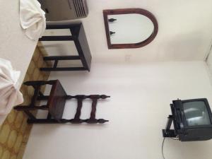 Habitación con TV y espejo en la pared. en Hotel Mediterraneo en Villa Carlos Paz