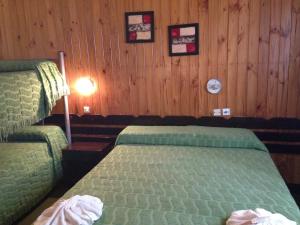 a bedroom with two beds in a room with wooden walls at Hotel Mediterraneo in Villa Carlos Paz