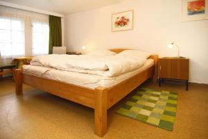 1 dormitorio con cama de madera y alfombra verde en Cottage, Schorfheide, en Schorfheide
