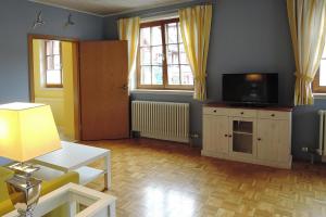 ein Wohnzimmer mit einem TV, einem Sofa und einem Tisch in der Unterkunft Apartment Bears, Meersburg in Meersburg