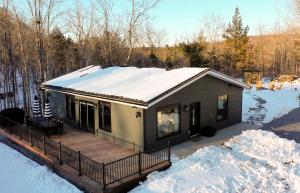 a small house with a deck in the snow at Acorn Bungalow - Luxury Cabin, Catskills, Windham Mountain, Hunter Mountain in Cairo