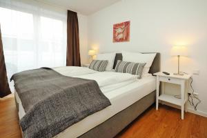 a bedroom with a large white bed with a night stand at Apartment in Lissendorf with a terrace in Lissendorf