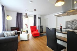 ein Wohnzimmer mit einem Sofa und einem roten Stuhl in der Unterkunft Apartment in Lissendorf with a terrace in Lissendorf