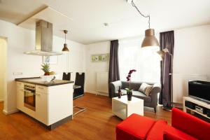 eine Küche und ein Wohnzimmer mit einem roten Sofa in der Unterkunft Apartment in Lissendorf with a terrace in Lissendorf