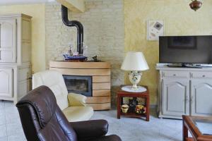 uma sala de estar com uma cadeira e uma lareira em Cottage, Perros Guirec em Saint-Quay-Perros