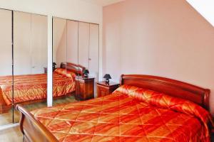 a bedroom with two beds with orange comforter at Cottage, Perros Guirec in Saint-Quay-Perros
