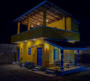 um edifício amarelo com portas azuis e um telhado em Bliss Beach em Negombo
