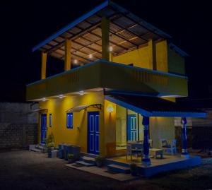 un bâtiment jaune avec des portes bleues et un toit dans l'établissement Bliss Beach, à Negombo