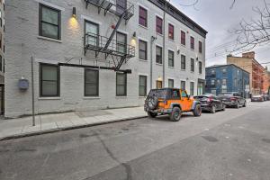 una jeep arancione parcheggiata sul lato di una strada cittadina di Sunny Dtwn Apartment, Walk to Washington Park a Cincinnati