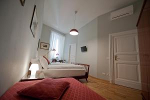 a bedroom with two beds and a window and a door at Cassiodoro19 in Rome