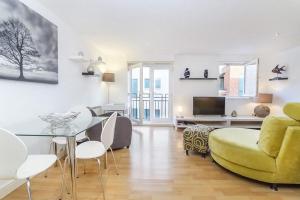 a living room with a table and a yellow chair at Strand House- Long Stays only in York