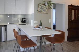 una cocina con mesa con sillas y una botella de vino en Apartment Beg Meil, en Fouesnant